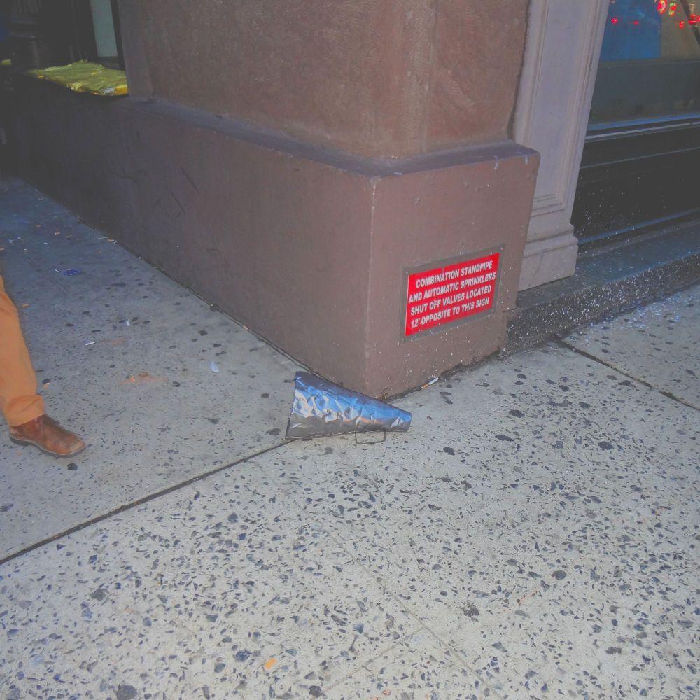 A metal megaphone discarded on a street corner